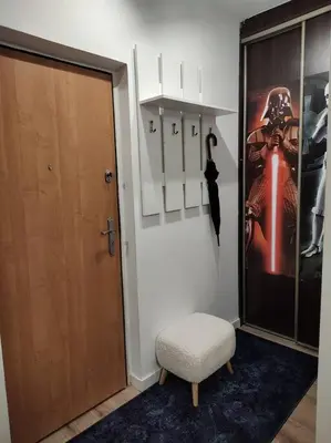 a room with a door and a chair and a poster at Star Wars Climate Apartment in Kraków