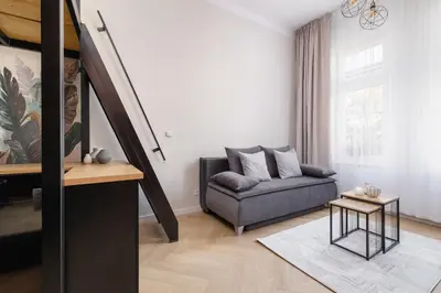 a living room with a couch and a staircase at Studio apartment - Berka Joselewicza 5 street in Kraków