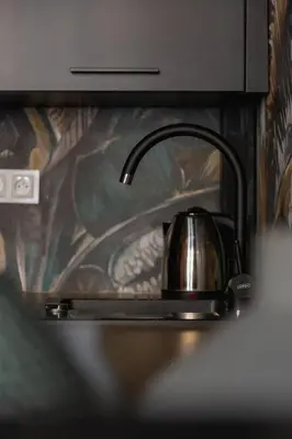a tea kettle sitting on top of a kitchen sink at Studio apartment - Berka Joselewicza 5 street in Kraków