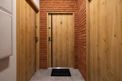 a wooden door with a sign in front of a brick wall at Studio apartment - Berka Joselewicza 5 street in Kraków