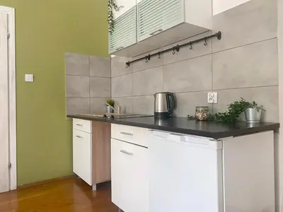 a kitchen with white cabinets and a black counter top at Large 89m2 Apartment, 3 bedrooms and 2 bathrooms in Kraków