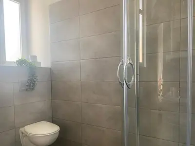 a bathroom with a toilet and a glass shower at Large 89m2 Apartment, 3 bedrooms and 2 bathrooms in Kraków