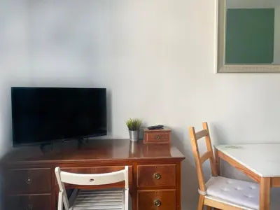 a desk with a tv on top of it with a chair at Large 89m2 Apartment, 3 bedrooms and 2 bathrooms in Kraków