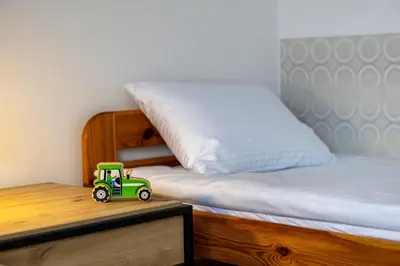 a toy tractor sitting on a desk next to a bed at Ostoja w Górach in Bieńkówka
