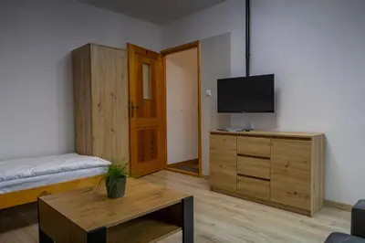 a room with a bedroom with a bed and a tv at Ostoja w Górach in Bieńkówka