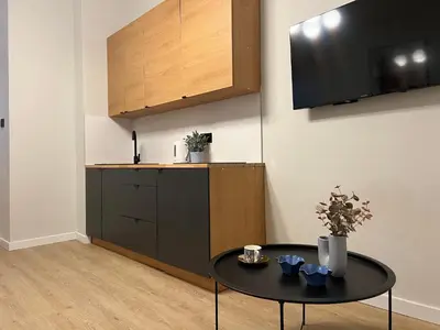 a living room with a table and a tv at Corner Apartments in Kraków