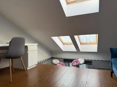 a attic room with skylights and a table and chairs at Corner Apartments in Kraków