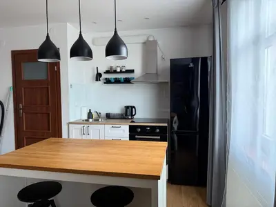 a kitchen with a black refrigerator and a wooden counter top at Corner Apartments in Kraków