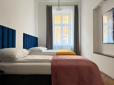 a bedroom with two beds and a window at Corner Apartments in Kraków