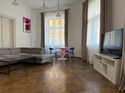 a living room with a couch and a tv and a table at Corner Apartments in Kraków