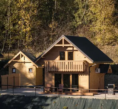 a log home with a black roof at Łysogórska Polana Domki in Mordarka