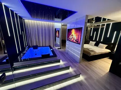 a bathroom with a tub in a room with a bed at Masarska 6 VIP Apartamenty JACUZZI in Kraków