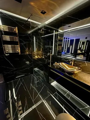 a bathroom with a black counter top and a sink at Masarska 6 VIP Apartamenty JACUZZI in Kraków