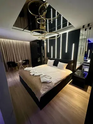 a bedroom with a large bed with a chandelier at Masarska 6 VIP Apartamenty JACUZZI in Kraków