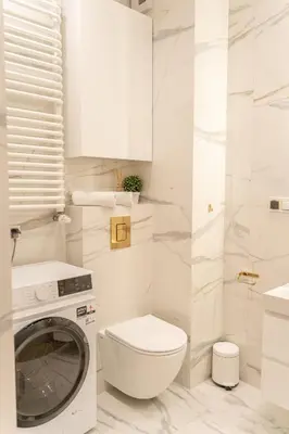 a white bathroom with a washing machine in it at K&M Apartments Near Tauron Arena in Kraków