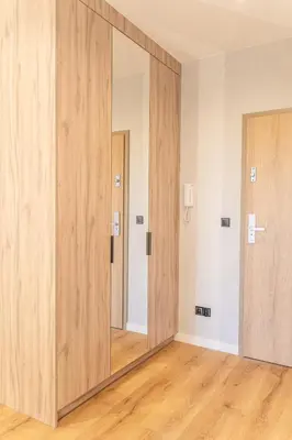 an empty room with a large mirror and wooden doors at K&M Apartments Near Tauron Arena in Kraków