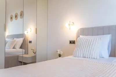 a bedroom with a white bed and a mirror at K&M Apartments Near Tauron Arena in Kraków