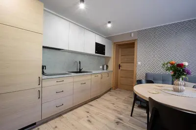 a kitchen with a table and a dining room at Zacisze pod Chełmem in Stryszów