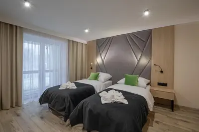 two beds in a hotel room with towels on them at Zacisze pod Chełmem in Stryszów
