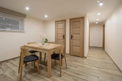 a dining room with a wooden table and chairs at Zacisze pod Chełmem in Stryszów