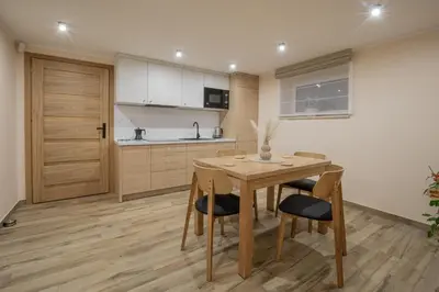 a kitchen with a wooden table and chairs at Zacisze pod Chełmem in Stryszów