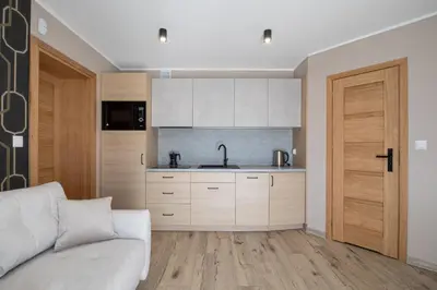 a living room with a couch and a kitchen at Zacisze pod Chełmem in Stryszów