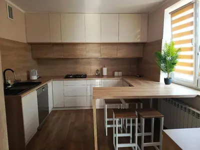 a kitchen with white cabinets and a wooden table at Apartament U ELI z prywatnym tarasem in Oświęcim