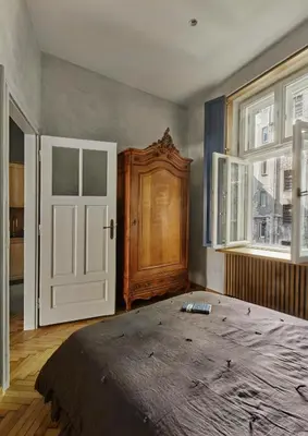 a bedroom with a large bed and a wooden door at Luella in Kraków