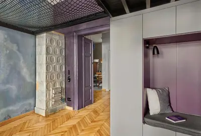a hallway with purple walls and a chair in a room at Luella in Kraków