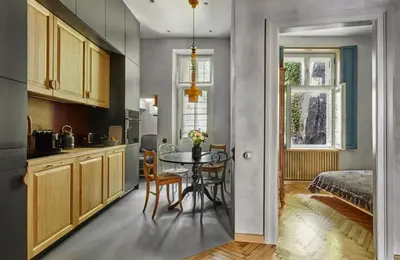 a kitchen and dining room with a table and a bed at Luella in Kraków