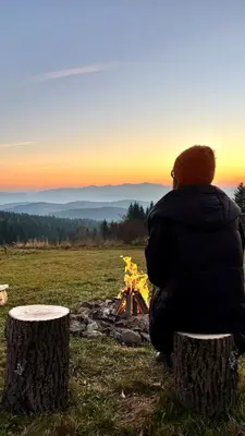 a person sitting next to a camp fire at Closer to Heaven, 825m above sea, Koskowa Mtn in Bogdanówka