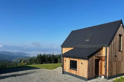 a wooden barn with a black roof on a hill at Closer to Heaven, 825m above sea, Koskowa Mtn in Bogdanówka
