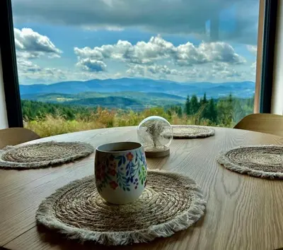 a table with a coffee cup and plates on it at Closer to Heaven, 825m above sea, Koskowa Mtn in Bogdanówka