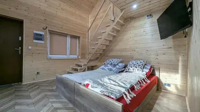 a room with a bed in a wooden wall at Domek wypoczynkowy Górskie Zacisze II in Sidzina