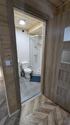 a bathroom with a toilet and a glass shower at Domek wypoczynkowy Górskie Zacisze II in Sidzina