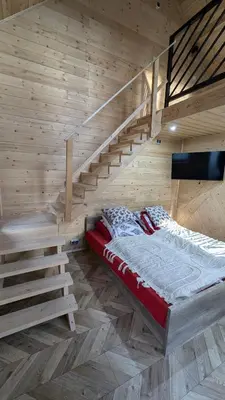 a bedroom with a bed in a wooden wall at Domek wypoczynkowy Górskie Zacisze II in Sidzina