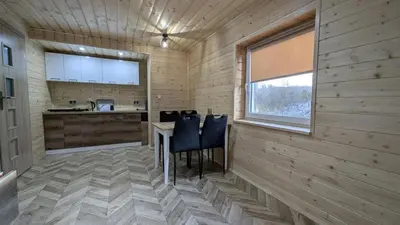 a kitchen with wooden walls and a table and chairs at Domek wypoczynkowy Górskie Zacisze II in Sidzina