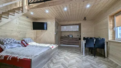 a room with a bed and a table and a kitchen at Domek wypoczynkowy Górskie Zacisze II in Sidzina