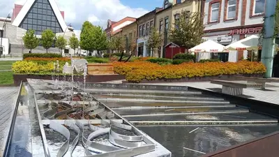 a fountain in the middle of a street with buildings at Na Podwalu in Jaworzno