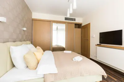a bedroom with a bed with white pillows and a television at RentPlanet - Angel Plaza in Kraków