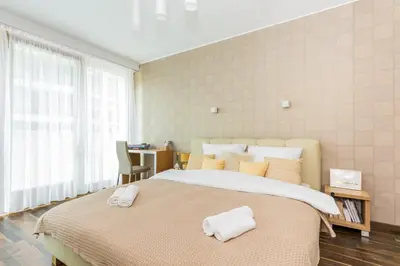 a bedroom with a large bed with towels on it at RentPlanet - Angel Plaza in Kraków