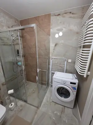 a bathroom with a shower and a washing machine at New 1-Bdrm Apt in Beautiful Kraków in Kraków