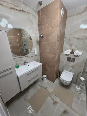 a bathroom with a sink and a toilet and a mirror at New 1-Bdrm Apt in Beautiful Kraków in Kraków