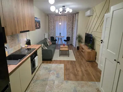 a kitchen and living room with a couch and a table at New 1-Bdrm Apt in Beautiful Kraków in Kraków