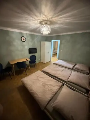 a bedroom with two beds and a table and a clock at Mieszkaj u Marty stale na Stałym in Jaworzno