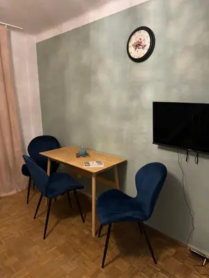 a room with a table and chairs and a clock at Mieszkaj u Marty stale na Stałym in Jaworzno