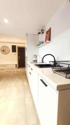 a kitchen with white cabinets and a counter top at Krowoderska 55 by Homeprime in Kraków