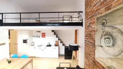 a loft apartment with a loft bed and a brick wall at Krowoderska 55 by Homeprime in Kraków