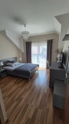 a large bedroom with a bed and a large window at Olszynowy Gaj 4 in Liszki