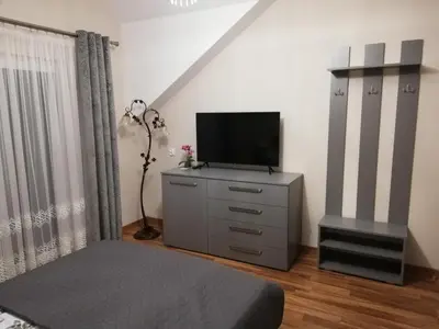 a bedroom with a dresser with a television on it at Olszynowy Gaj 4 in Liszki